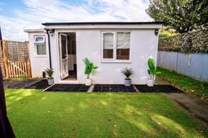 una casa blanca con plantas en un patio en Little Garden View, en Saint Albans