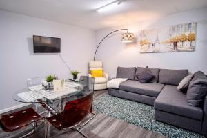 a living room with a couch and a glass table at Little Garden View in St. Albans