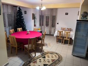 CosteştiにあるPension Nicoletaのピンクのテーブルとクリスマスの木があるダイニングルーム