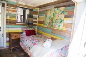 a bedroom with a bed and a wooden wall at Casa Tavaita in Karangahake gorge in Paeroa