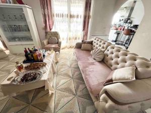 ein Wohnzimmer mit einem großen Sofa und einem Tisch in der Unterkunft Demeure - Haut Standing 11min Paris CDG in Dammartin-en-Goële