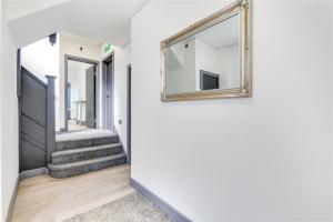 un espejo en una pared junto a un pasillo con escaleras en Modern Designer Studio Flat London, en Londres