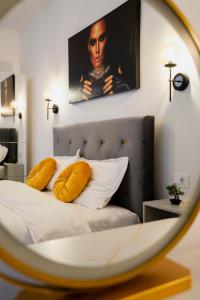 a bedroom with a bed with yellow pillows and a mirror at Casa Paul in Braşov