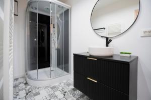 a bathroom with a black vanity and a mirror at Casa Paul in Braşov