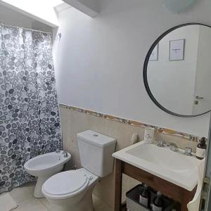 a bathroom with a toilet and a sink and a mirror at La Casa de Bimba in Gualeguaychú