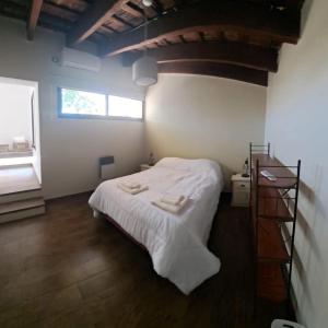 a bedroom with a bed with white sheets and a window at La Casa de Bimba in Gualeguaychú