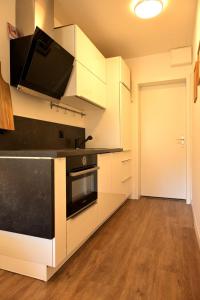uma cozinha com armários brancos e um forno preto em ArosaFlair em Arosa