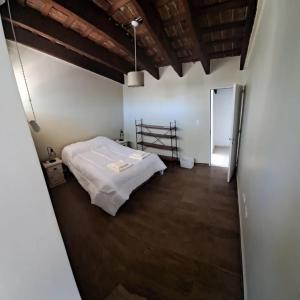 ein Schlafzimmer mit einem weißen Bett in einem Zimmer in der Unterkunft La Casa de Bimba in Gualeguaychú