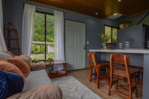 sala de estar con cocina con mesa y sillas en Villa Golondrina Cabaña rodeada de Naturaleza, en Monteverde