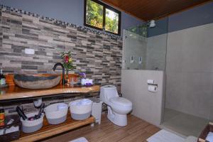 une salle de bain avec un lavabo, des toilettes et une douche dans l'établissement Villa Golondrina Cabaña rodeada de Naturaleza, à Monteverde Costa Rica