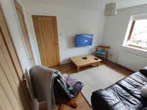 a living room with a couch and a table at 3-Bedroom Eco-house with EV charger. in Rosemarkie