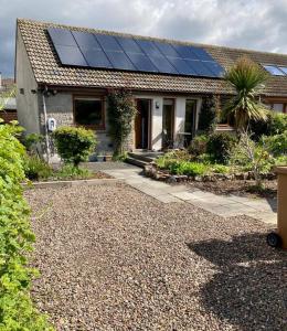 a house with solar panels on top of it at 3-Bedroom Eco-house with EV charger. in Rosemarkie