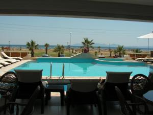 a view of a swimming pool with chairs and a table at Amphora Hotel in Ayvalık
