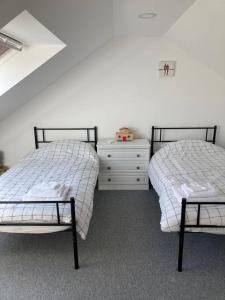 two beds sitting next to each other in a room at 3-Bedroom Eco-house with EV charger. in Rosemarkie