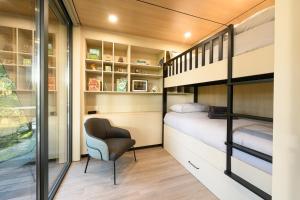 Dormitorio pequeño con litera y silla en Forest Lodges, en Betws-y-coed