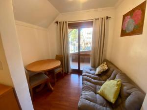 uma sala de estar com um sofá e uma mesa em Pousada Habitue em Gramado