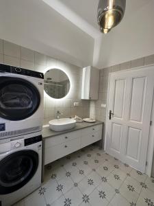 a bathroom with a washing machine and a sink at Kaštieľ Ladce 