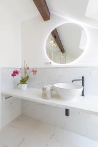 a white bathroom with a sink and a mirror at Penthouse with Whirlpool Central in Düsseldorf