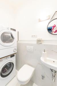 a white bathroom with a washing machine and a sink at Penthouse with Whirlpool Central in Düsseldorf
