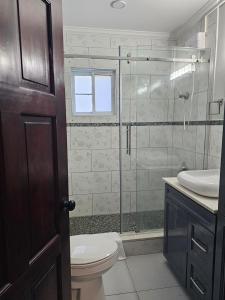 a bathroom with a toilet and a glass shower at Secret Hideaway in Ocho Rios