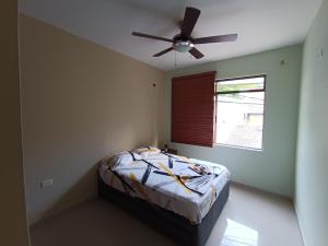 1 dormitorio con 1 cama y ventilador de techo en La terraza casa de verano en Melgar