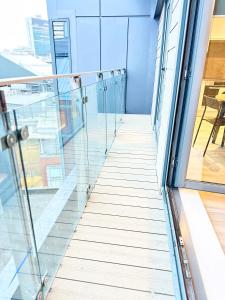 曼徹斯特的住宿－City centre, Top floor apartment, Two balconies，办公室大楼内有玻璃窗户的空走廊