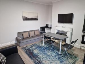 een woonkamer met een bank en een tafel bij Birtley's Amethyst 3 bedroom Apt sleeps 6 Guest in Birtley