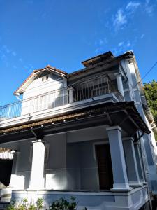 a white house with a balcony on top of it at Casarão Petrópolis Vintage - Hostel & Suítes in Petrópolis
