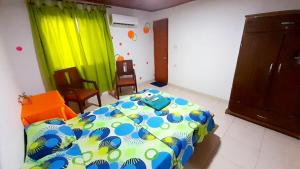 ein Schlafzimmer mit einem Bett und Stühlen in einem Zimmer in der Unterkunft Nahimara Champeta Hostel in Cartagena de Indias