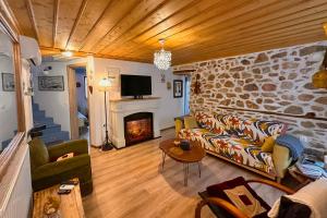 a living room with a couch and a fireplace at Renovated Old Manor House With Yard in Arnaia