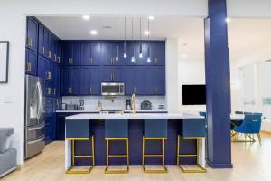 a kitchen with blue cabinets and a kitchen island with stools at Lake Home: Relax and Unwind in Mission Hidden Gem in Mission