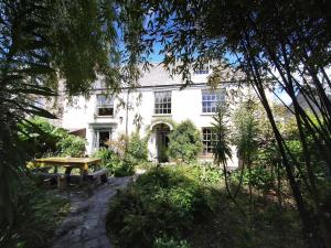 una casa blanca con una mesa de picnic delante de ella en Quay Street, en Lostwithiel