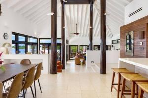 a living room with a dining table and chairs at Songbird 4 BR Anguilla Villa in The Valley