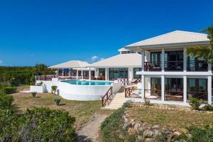 uma casa com uma piscina em frente em Songbird 4 BR Anguilla Villa em The Valley