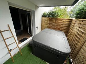a mattress sitting on the grass in a backyard at Secrète loft, spa & jaccuzi privatif - parking & bien-être près de Toulouse in Aucamville