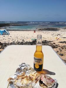 a bottle of beer and a fish on the beach at FurgoCamper Van H1 in Tetir