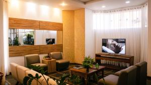 a living room with chairs and a tv and a table at Sir Hotel in Telêmaco Borba