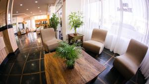 a lobby with chairs and a table in a store at Sir Hotel in Telêmaco Borba