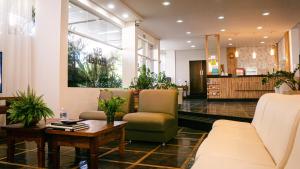 a lobby with a waiting room with chairs and a table at Sir Hotel in Telêmaco Borba +34 photos