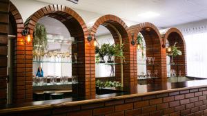 a bar in a restaurant with brick walls and arches at Sir Hotel in Telêmaco Borba
