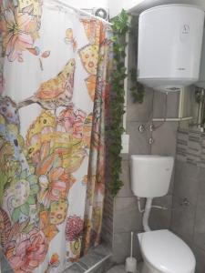 a bathroom with a toilet and a shower curtain at Apartmani Zaara in Sarajevo