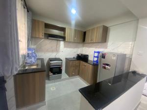 a kitchen with wooden cabinets and a stainless steel refrigerator at Meru Heights in Meru