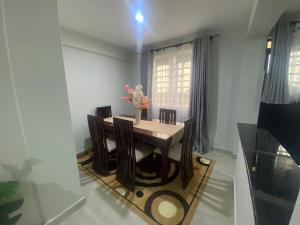 a dining room with a table and chairs and a window at Meru Heights in Meru