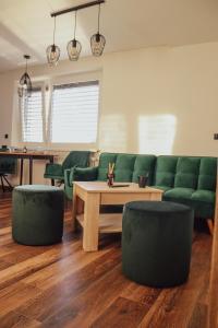 a living room with green couches and a table andools at IQ Apartments in Prešov