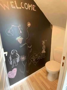 a bathroom with a black wall with drawings on it at Maison de ville epernay avec grande terrasse in Épernay +14 photos