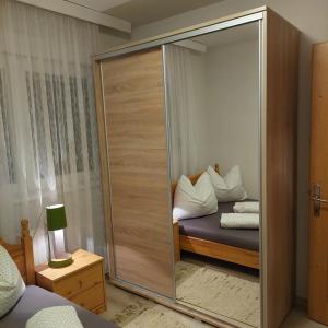 a room with a mirrored closet with a bed with pillows at Apartman BAGI in Kiseljak