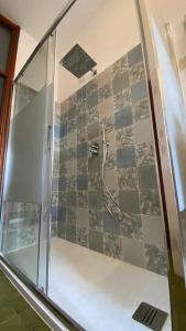 een douche met een glazen deur in de badkamer bij Saronno 800 mt dalla stazione in Saronno