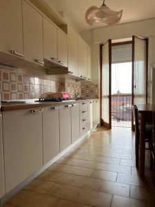 een keuken met witte kasten en een tafel. bij Saronno 800 mt dalla stazione in Saronno