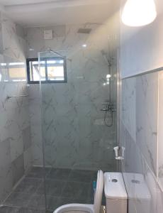 uma casa de banho com um chuveiro, um WC e um lavatório. em Executive Royal Suite Kado em Abuja