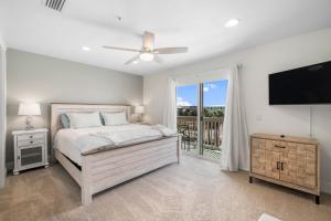 a bedroom with a bed and a flat screen tv at Sand Buckets Unit B, Ocean View Beach Townhouse in Mexico Beach +15 photos